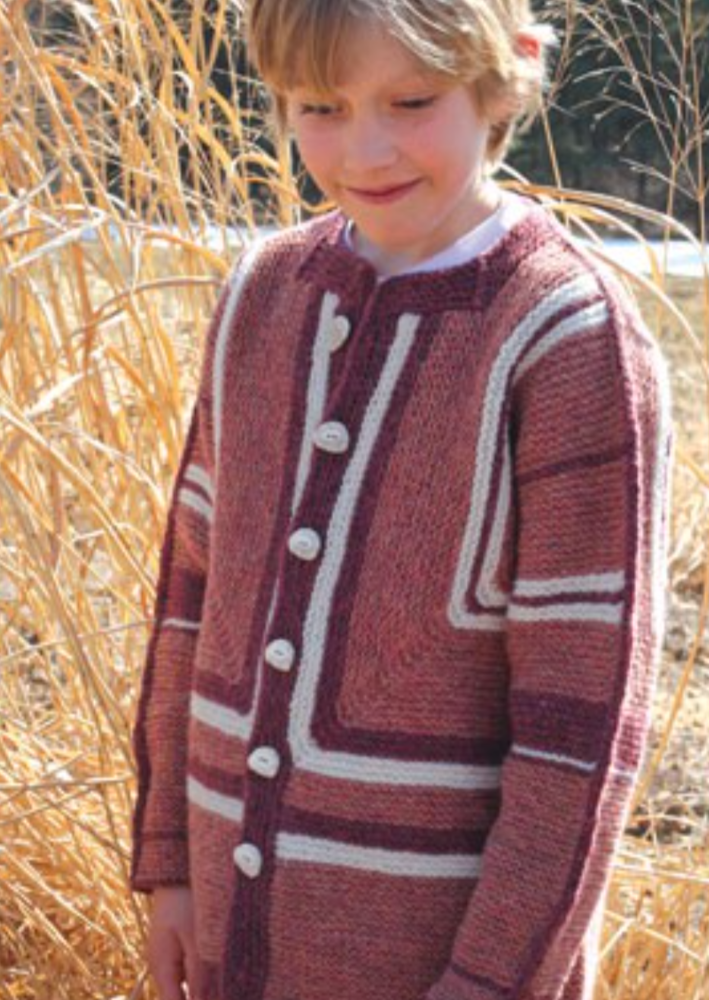 A young girl wearing a knitted jacket