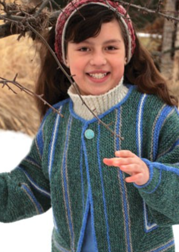 A young girl wearing a knitted jacket