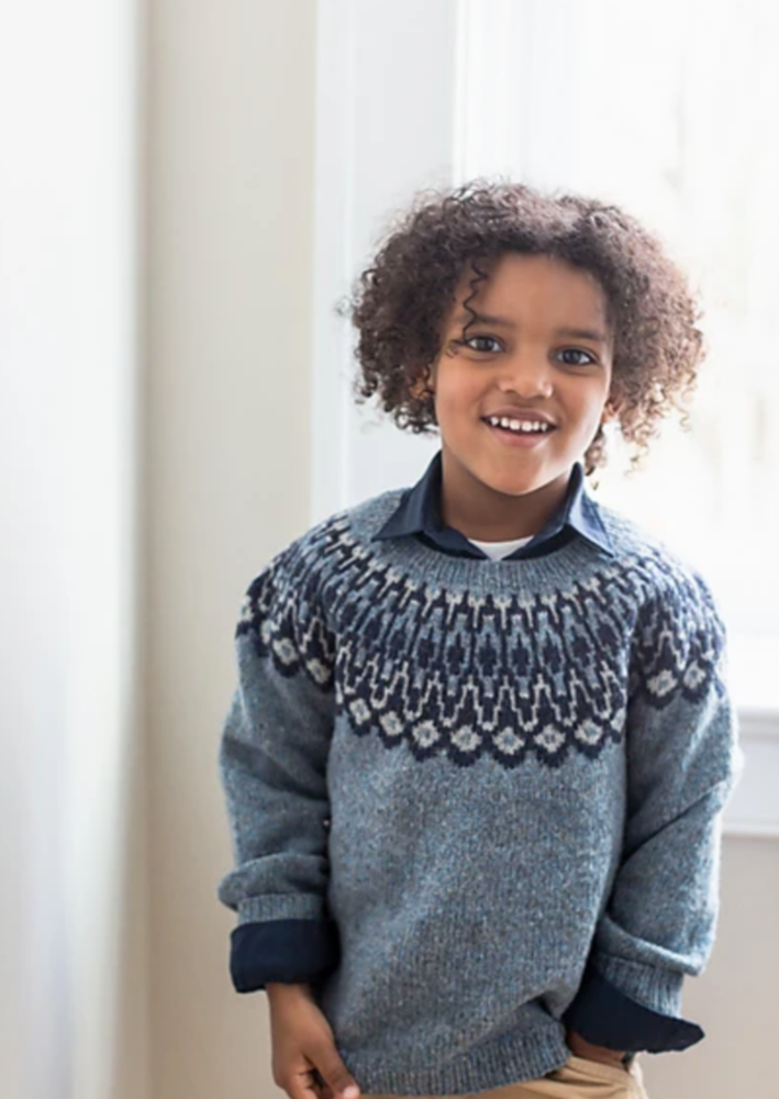 A boy wearing a knitted sweater