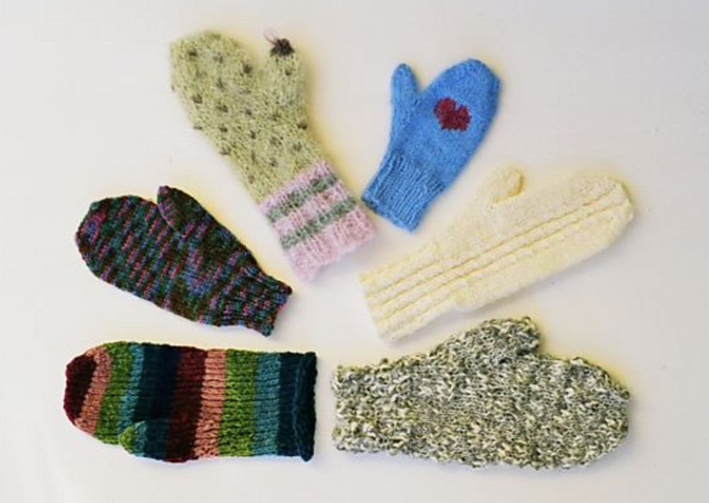 Six knitted mittens arranged in a semi-circle