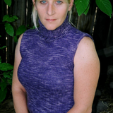 A woman wearing a sleeveless, knitted, turtleneck sweater