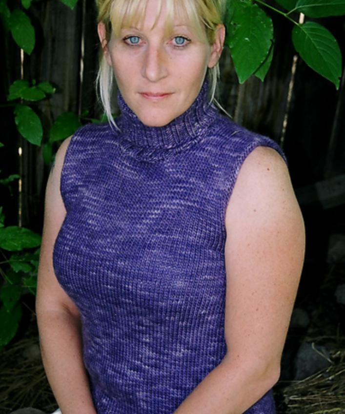 A woman wearing a sleeveless, knitted, turtleneck sweater