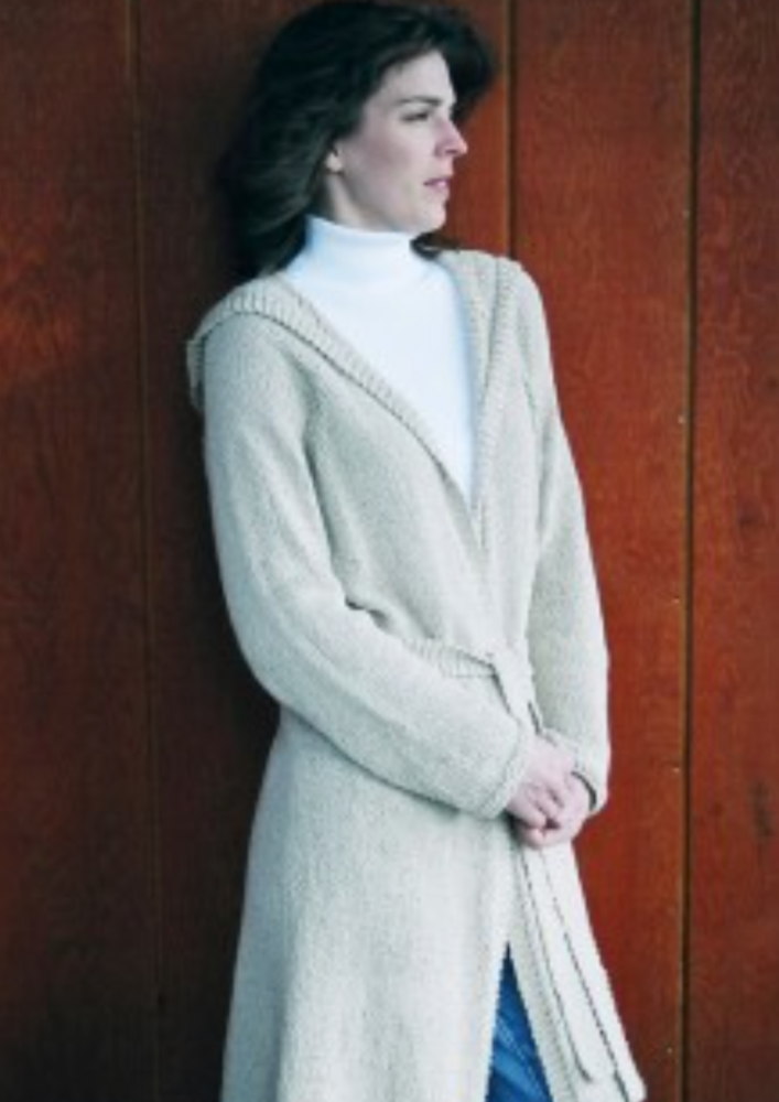 A woman wearing a long, knitted cardigan
