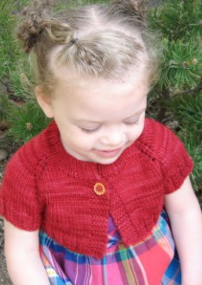 A female child wearing a knitted cardigan