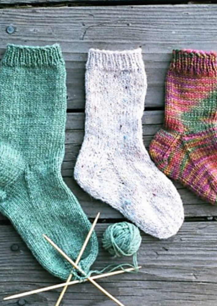 Three knitted socks and needles
