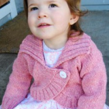 A female toddler wearing a knitted bolero sweater
