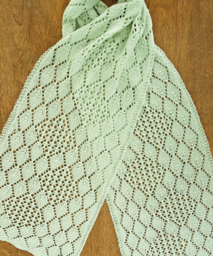 A lacy, knitted scarf on a wooden surface