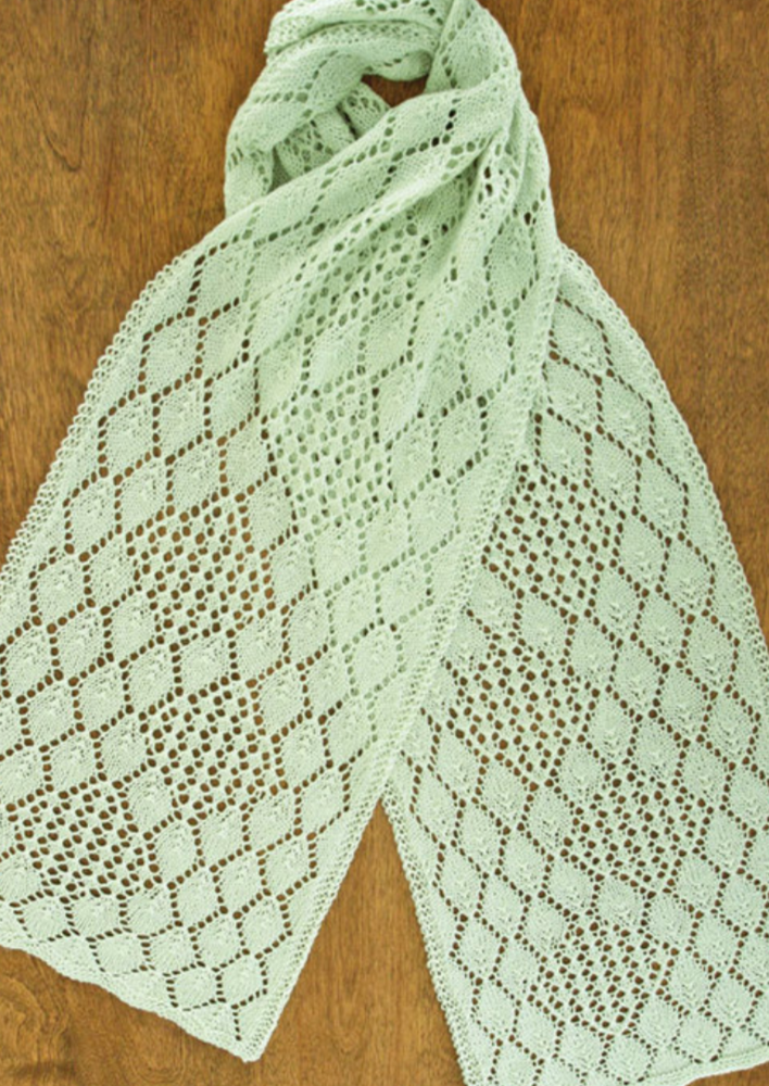 A lacy, knitted scarf on a wooden surface