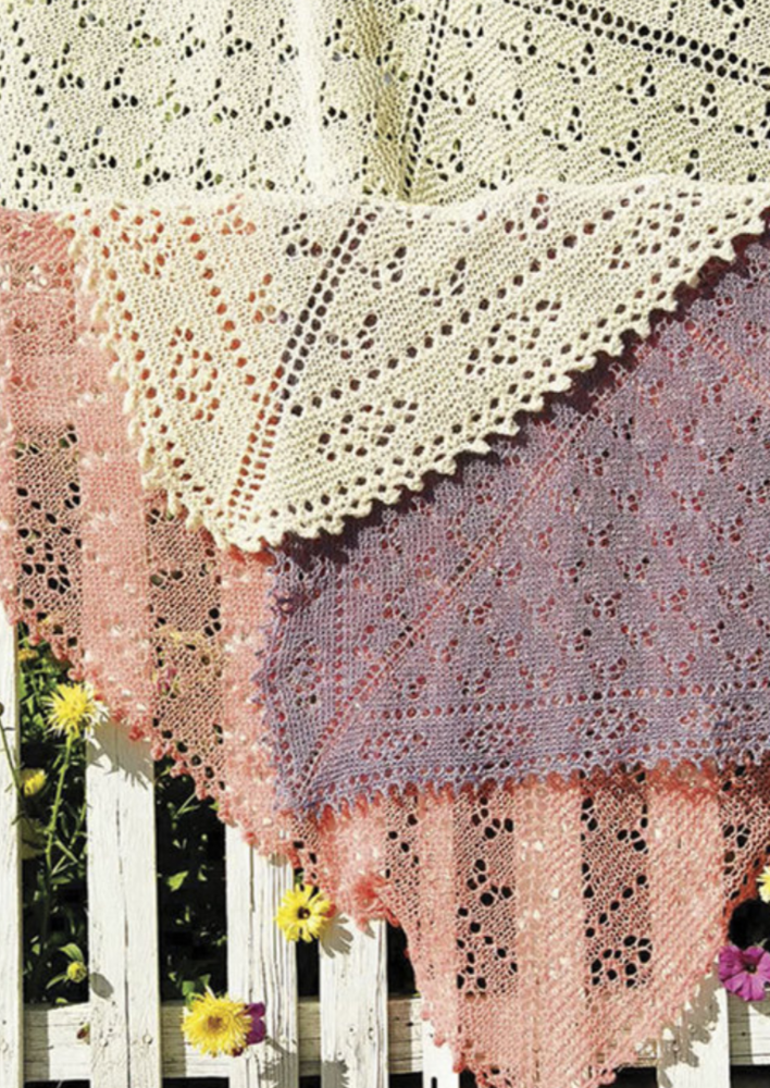 Several knitted shawls layered on top of each other