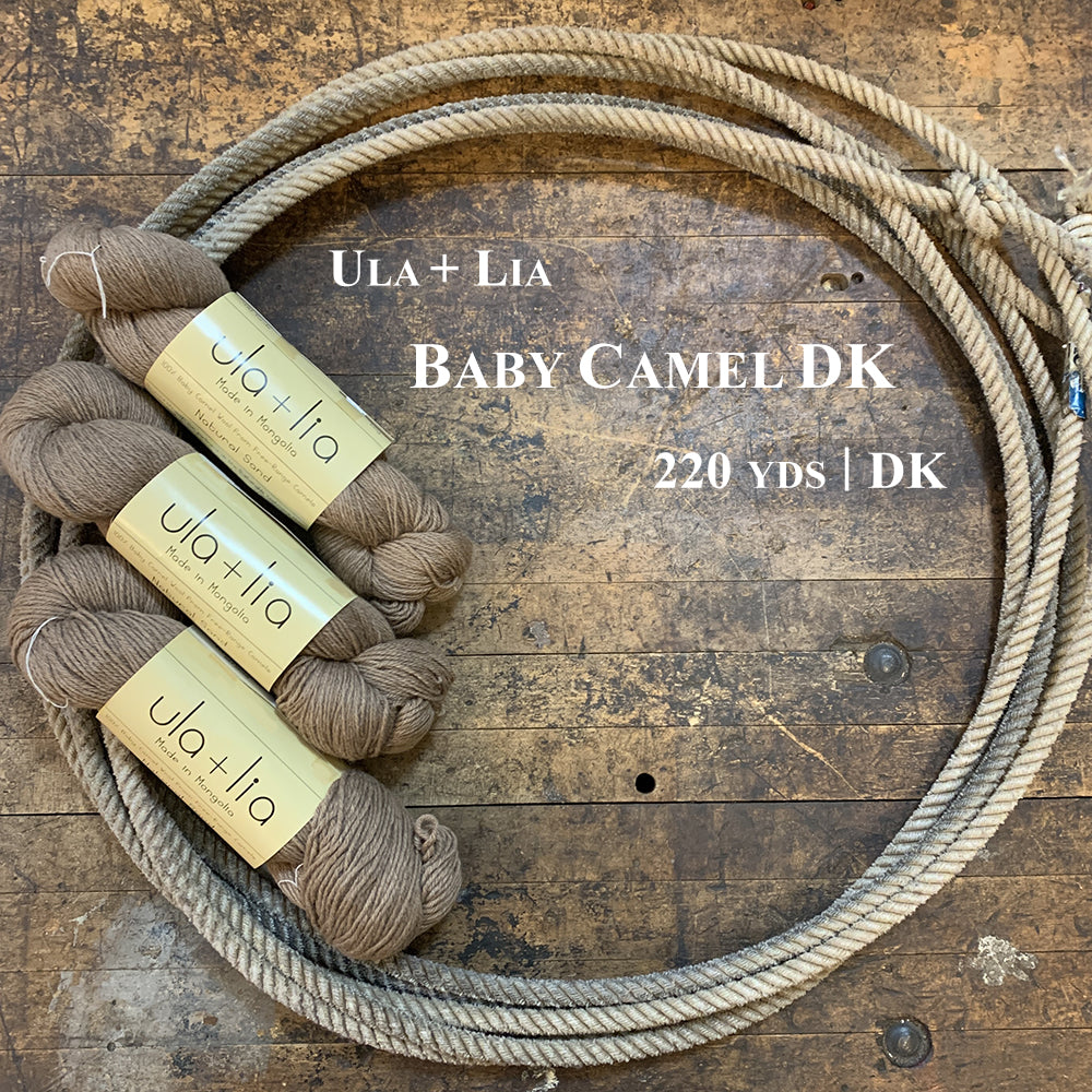 A photo of three hanks of baby camel Ula and Lia DK yarn in a lasso on a wooden surface