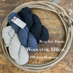 Skeins of Blue Sky Fibers Woolstok yarn on a wooden surface