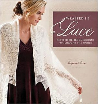 The book cover for "Wrapped in Lace" featuring a woman wearing a white knitted shawl, which says, "Knitted heirloom designs from around the world."