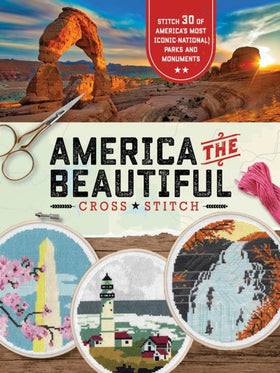 Cover of America the Beautiful Cross Stitch book. A photo of Arches National Park above the header and 3 cross stitch hoops below