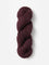 Skein of Blue Sky Fibers Woolstok yarn in the color maroon