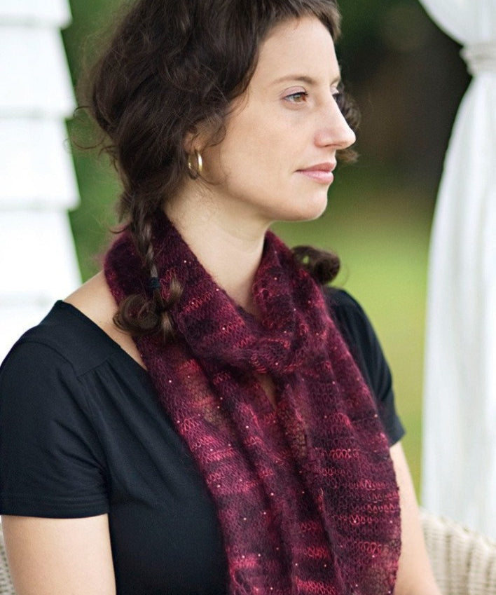 A woman wearing a beaded, knitted scarf
