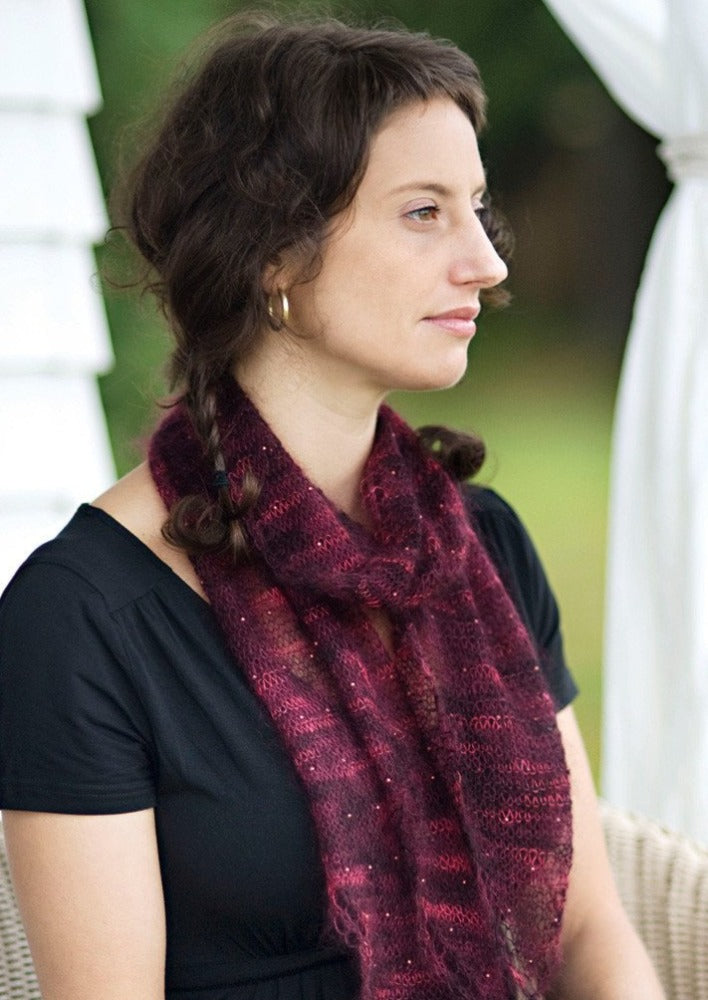 A woman wearing a beaded, knitted scarf