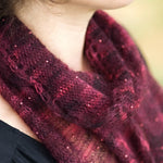 A woman wearing a beaded, knitted scarf