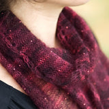 A woman wearing a beaded, knitted scarf