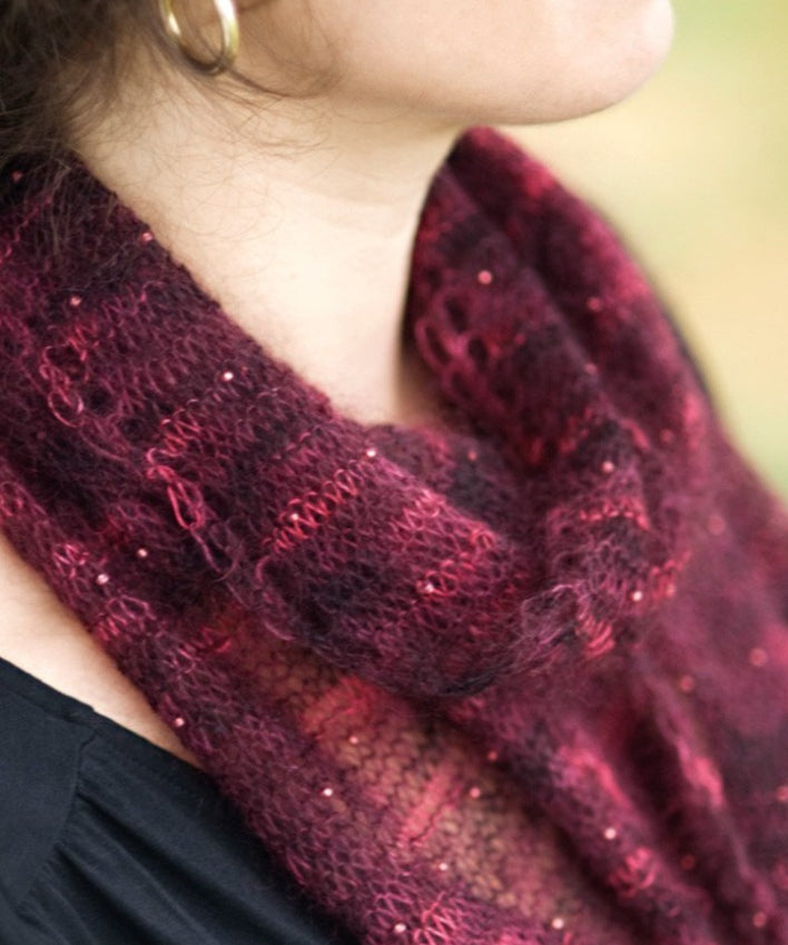 A woman wearing a beaded, knitted scarf