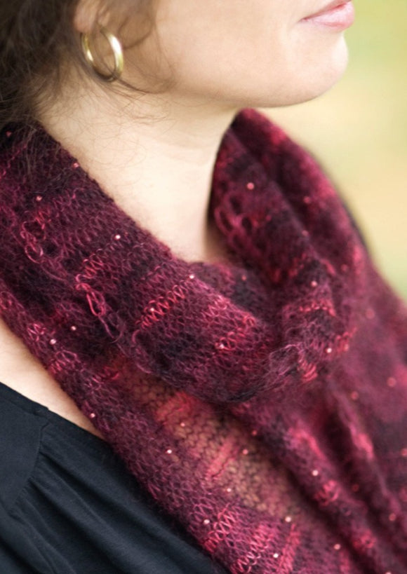 A woman wearing a beaded, knitted scarf
