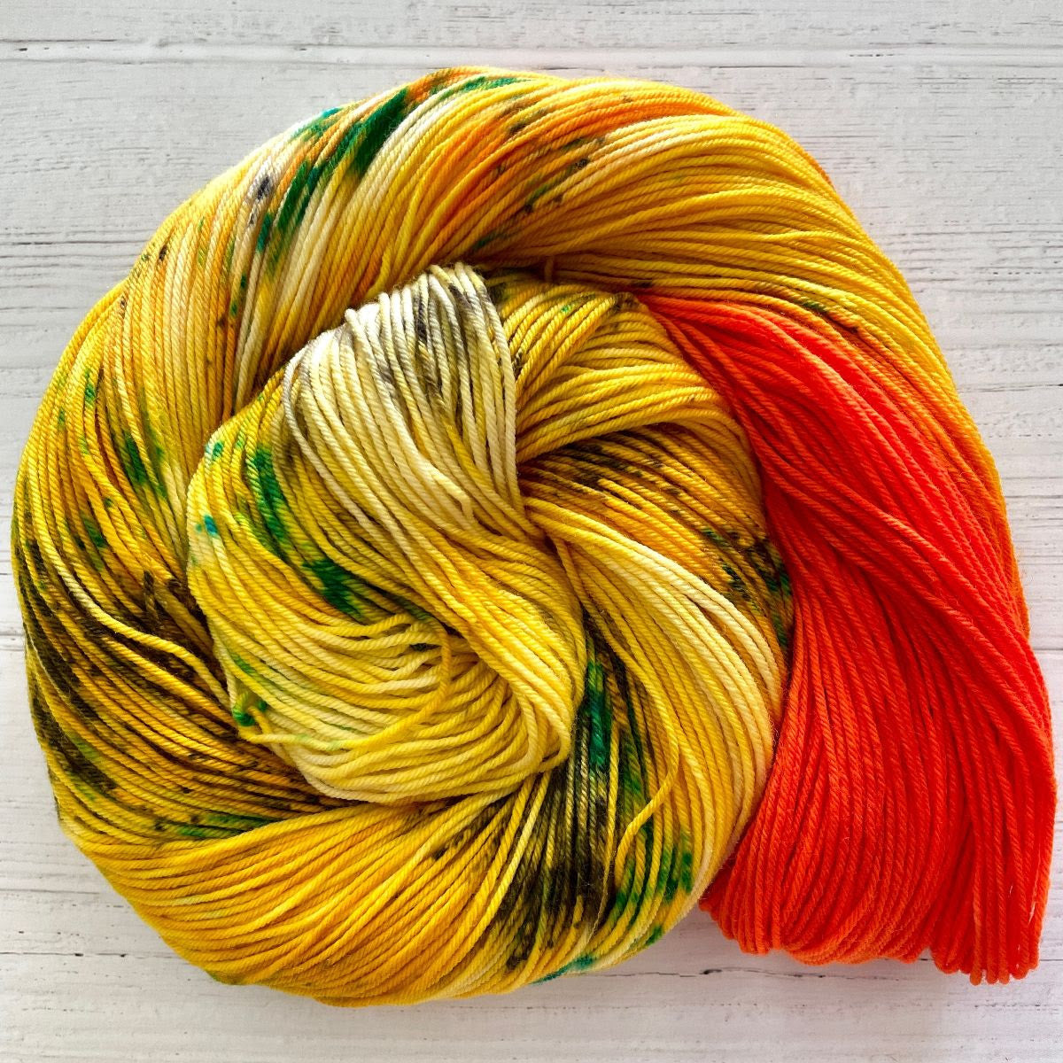 Knitted Wit Herstory 2022 yarn color Mango Street, a yellow/green/orange yarn, spiraled